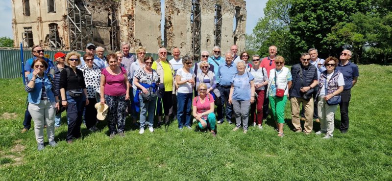 Uczestnicy wycieczki na tle ruin zamku w Bodzentynie